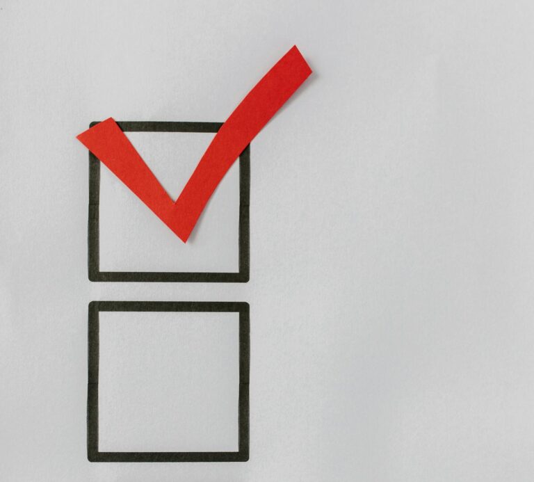 A checklist with a red tick mark over the first box on a white background symbolizing completion.